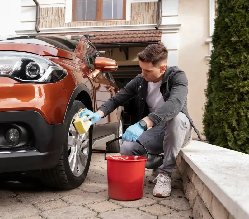 Lavage auto à domicile Ouzouer-le-Doyen : professionnel intervenant sur un véhicule